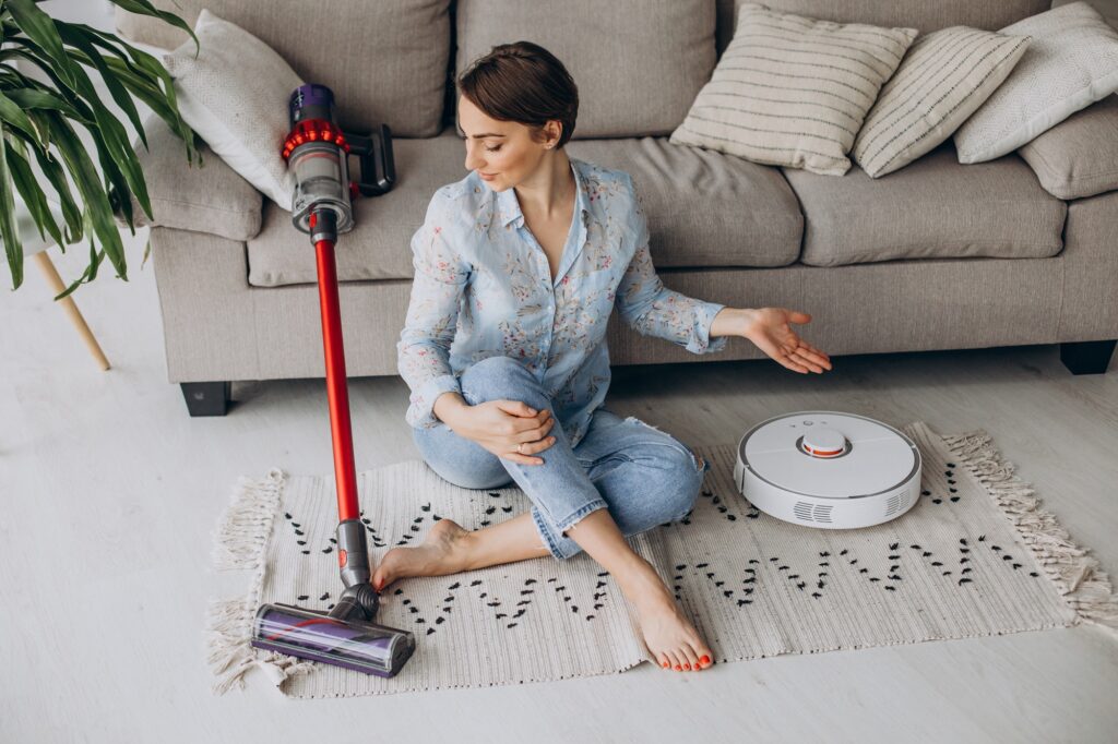 woman sitting on sofa and choosing vacuum cleaner